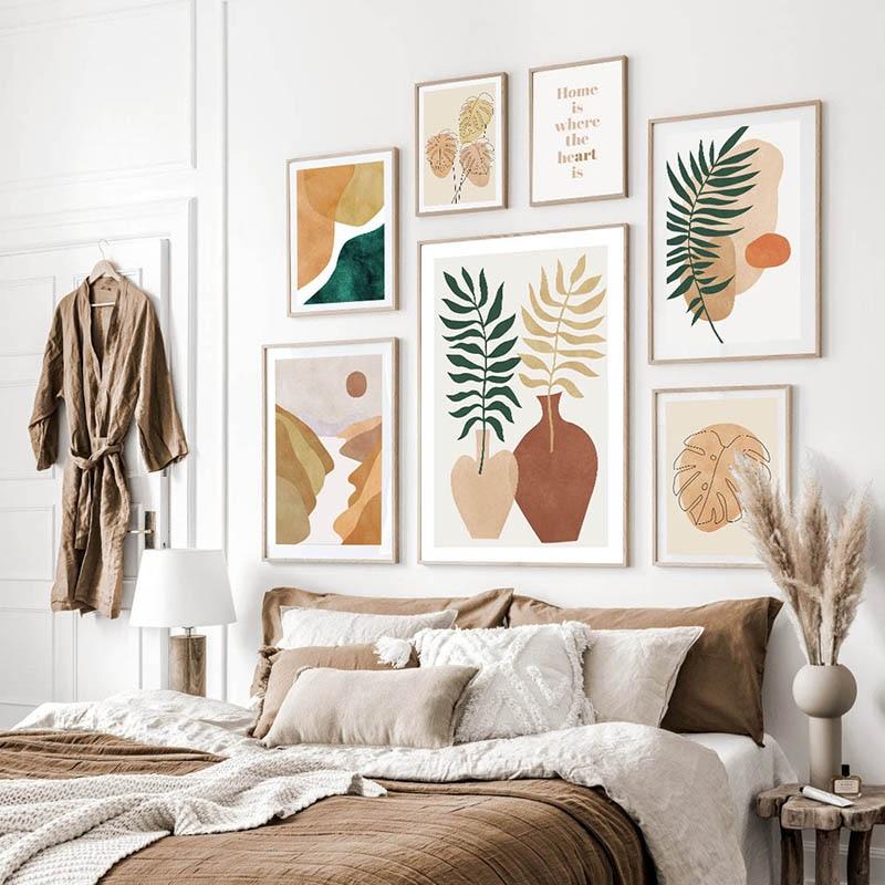 Boho canvas print gallery on white wall above bed.