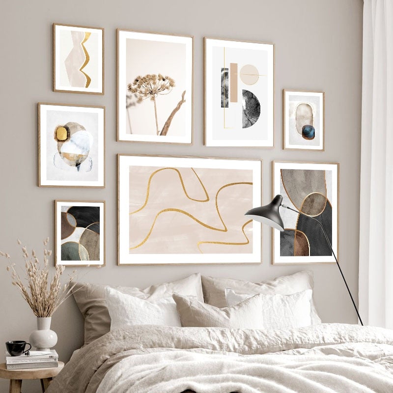 Abstract gold wall art set on bedroom wall above bed.