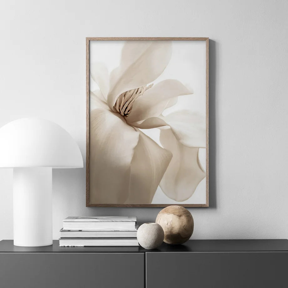 Framed floral artwork on a wall above a console table with decorative items.