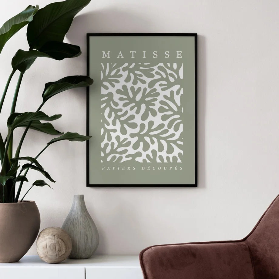 Framed Matisse art print on a wall with decorative items below.