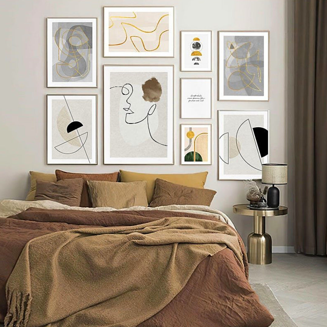 Gold white and grey wall art above bed in bedroom.