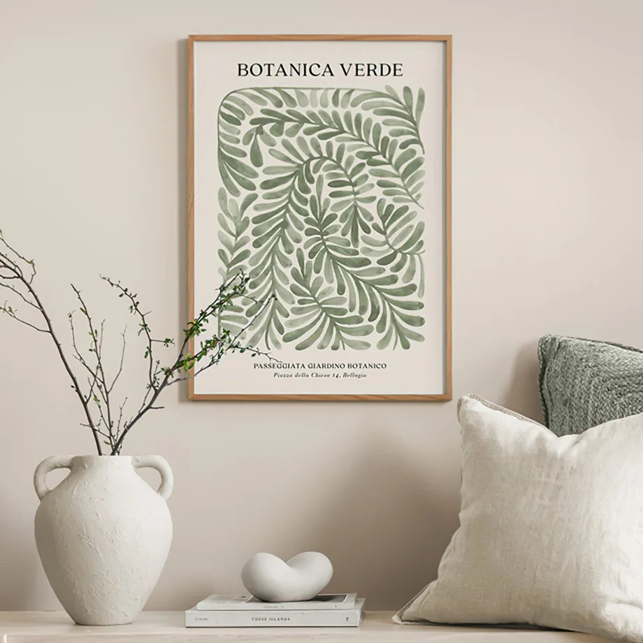 Green botanical canvas poster on beige wall.