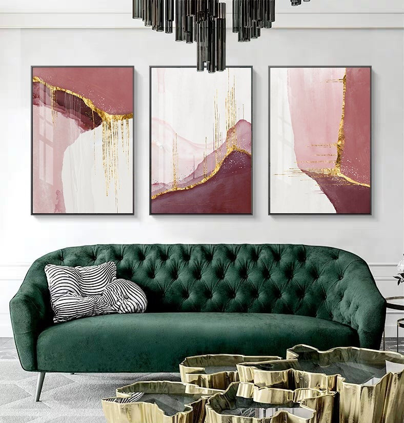 Pink and gold abstract poster set on wall above sofa.
