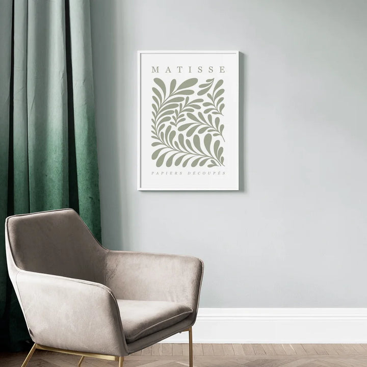 Framed artwork with 'Matisse' design on a wall above a chair.