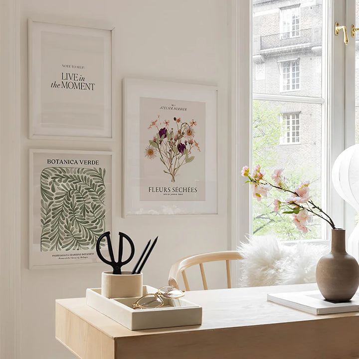 Floral canvas posters on study room wall behind desk.