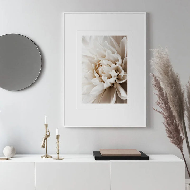 Framed floral artwork on a wall above a white console table with decorative items.