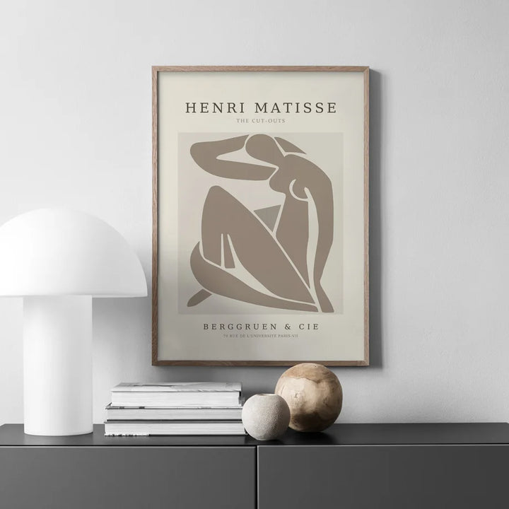 Henri matisse print in fawn and cream above grey sideboard.
