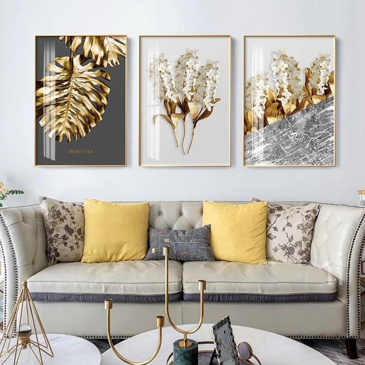 Grey and gold wall art on white living room wall.