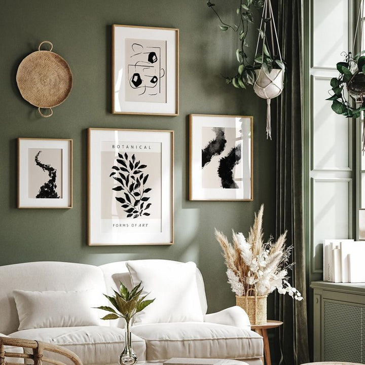 Black and beige abstract gallery on green living room wall.