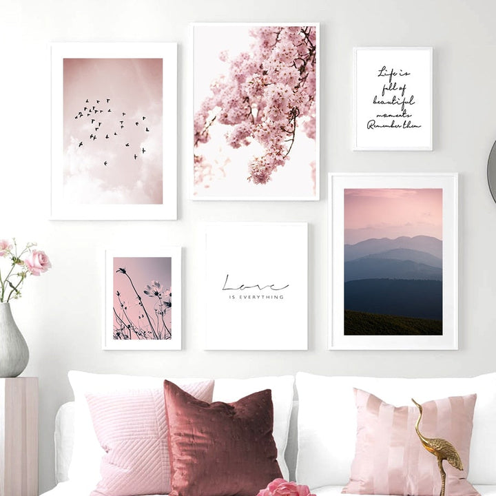 Pink floral wall art gallery on white living room wall.