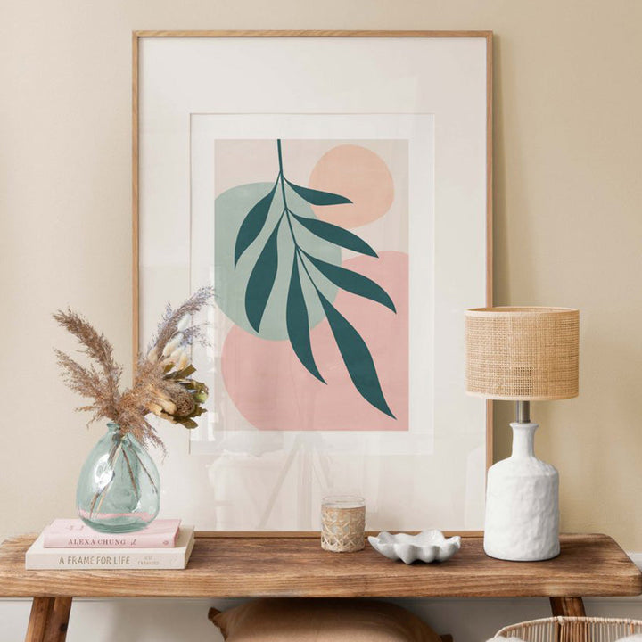 Colourful floral canvas poster in frame on desk.