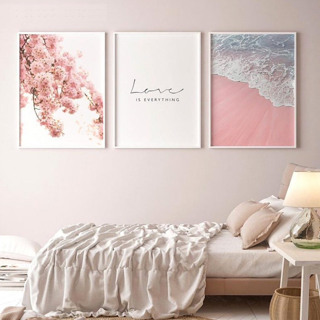 Pink prints and poster set on bedroom wall.