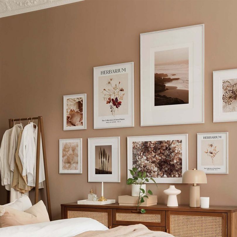 Floral prints on dark beige bedroom wall.