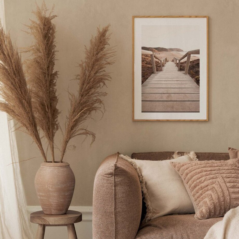 Nature photography framed print above sofa on beige wall.