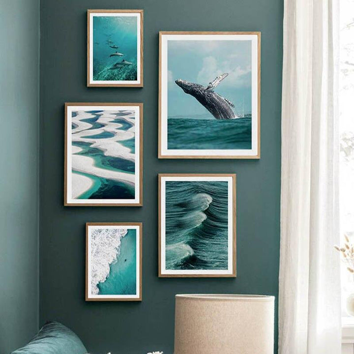 Ocean canvas posters on green living room wall.