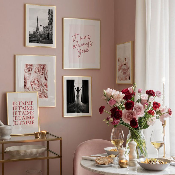 Pink poster gallery on pink dining room wall.