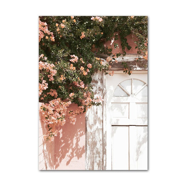 White door with pink flower tree hanging over canvas poster.